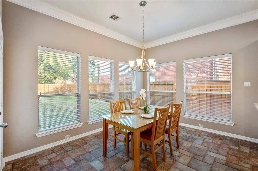 The bright and inviting breakfast area features five windows along the back and side, allowing natural light to flood the space and offering picturesque views of the backyard and side yard. It's the perfect spot to enjoy your morning coffee while soaking in the surroundings.
