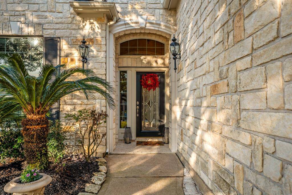 Welcome guests in style with this elegant glass front door, framed by a striking masonry archway. The intricate detailing adds a touch of sophistication while allowing natural light to brighten the entryway.