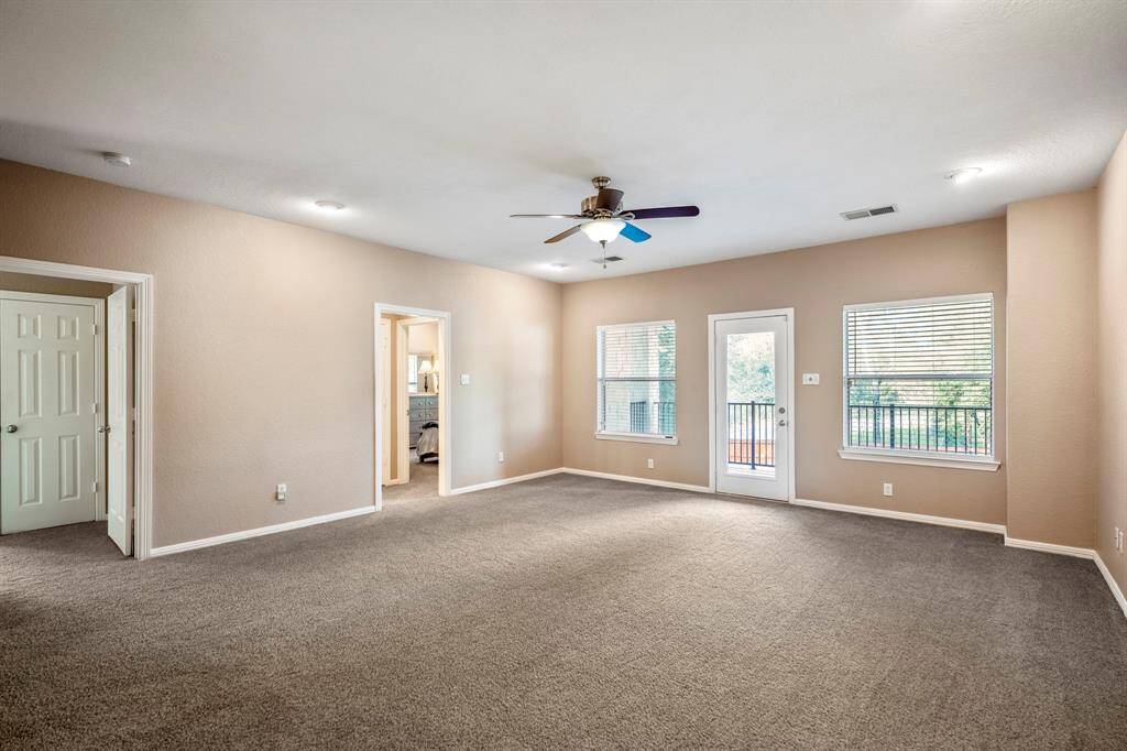 The loft-style game room offers a spacious and versatile upstairs retreat. To the left, you’ll find the entrance to the media room and the doorway leading to the second bedroom and bath area. Straight ahead, the exterior door opens to the upstairs balcony, providing a relaxing outdoor space with a view.