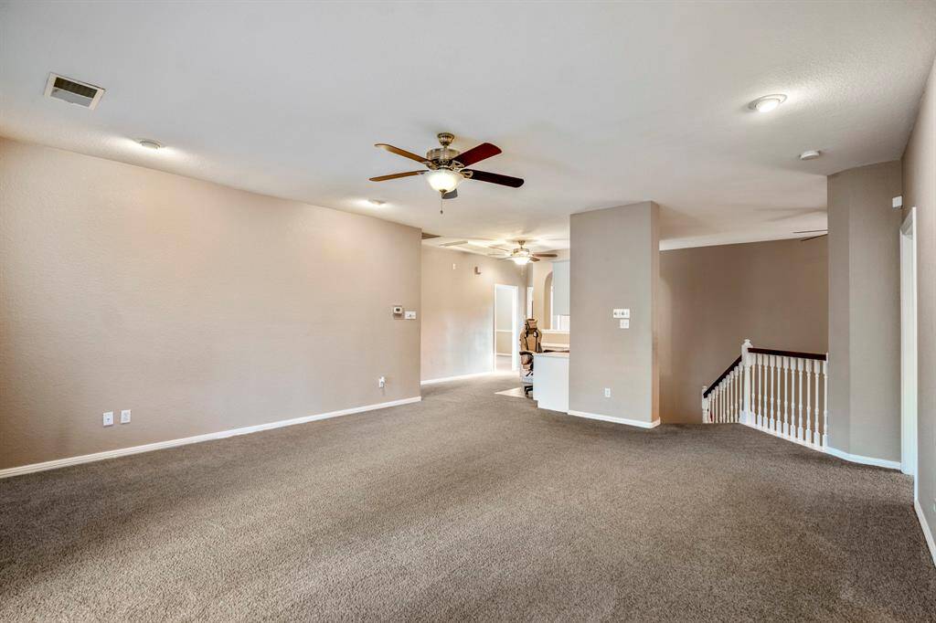 From the game room, looking toward the front of the home, you’ll see the staircase leading back downstairs to the right. To the left, a built-in study area with a desk and cabinets provides the perfect workspace or homework station.