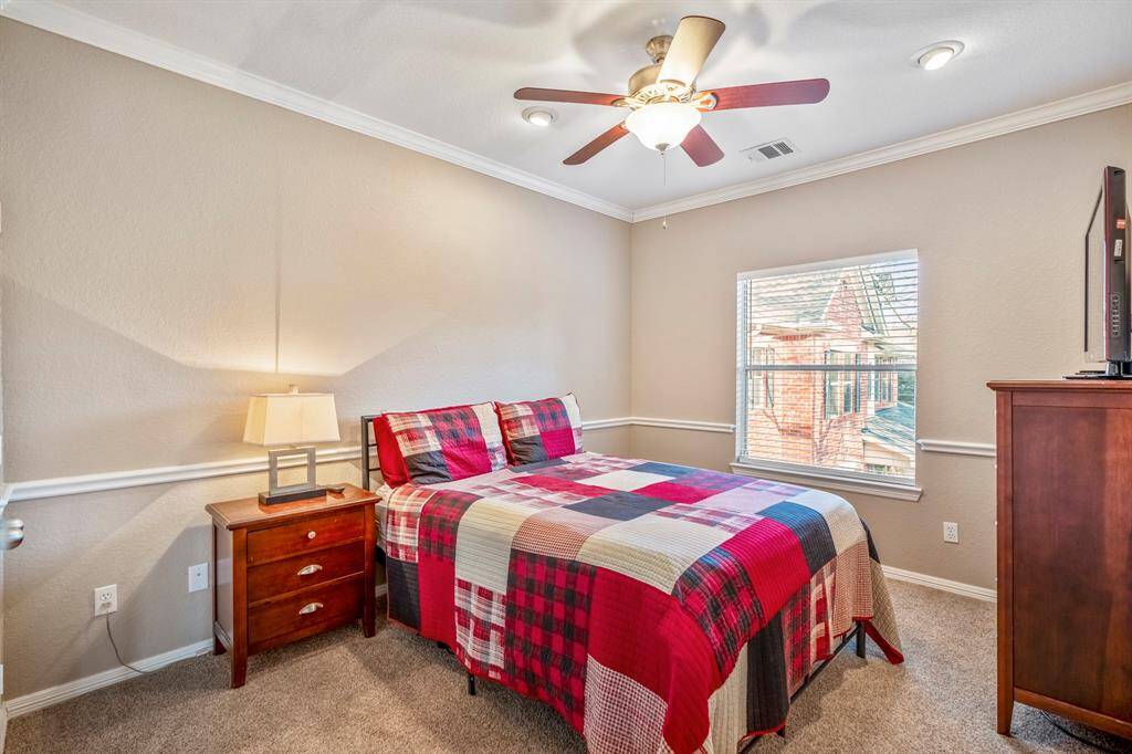 This charming upstairs bedroom features elegant chair railing and crown moulding, enhancing its refined feel. A large window floods the room with natural light. It connects to another bedroom through a Jack and Jill bathroom, providing both convenience and privacy.
