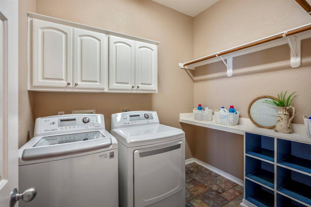The laundry room is designed for convenience with built-in cabinetry, shelving, and storage cubes, providing plenty of space for organization and keeping everything tidy. It’s a practical, functional area that adds to the home's overall efficiency.