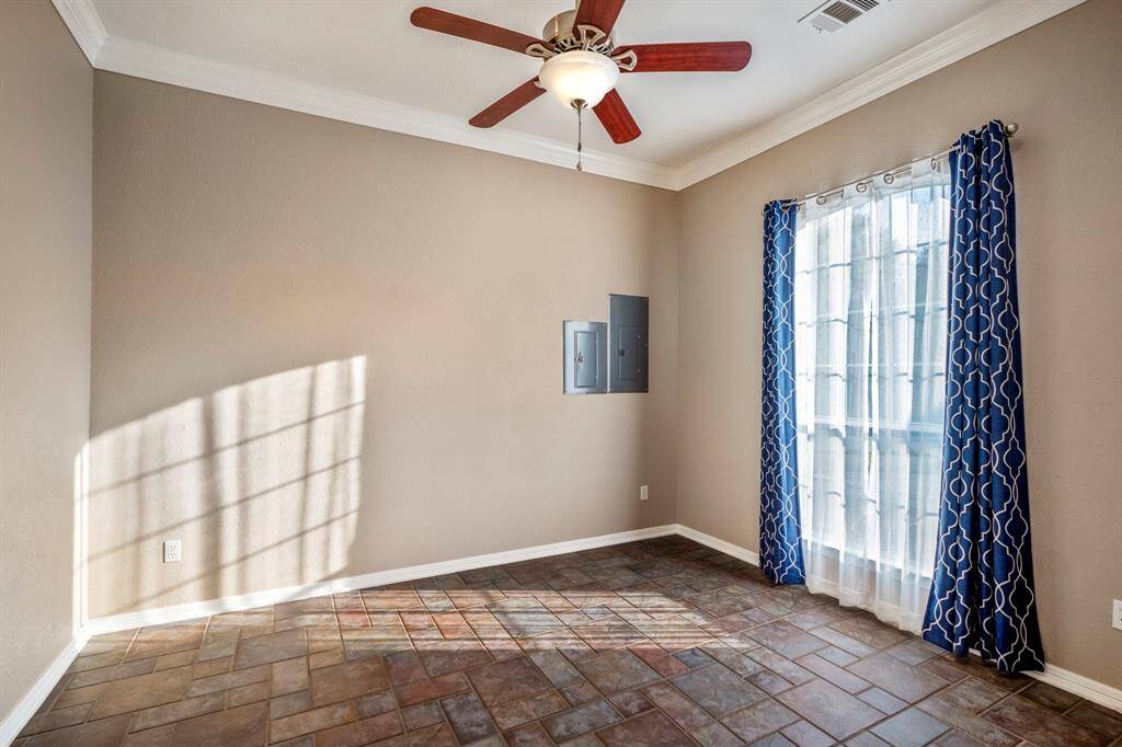 The third home office/study space features a large window overlooking the front of the home and the driveway area, allowing for plenty of natural light and a pleasant view. This versatile room offers a peaceful setting for work or study.