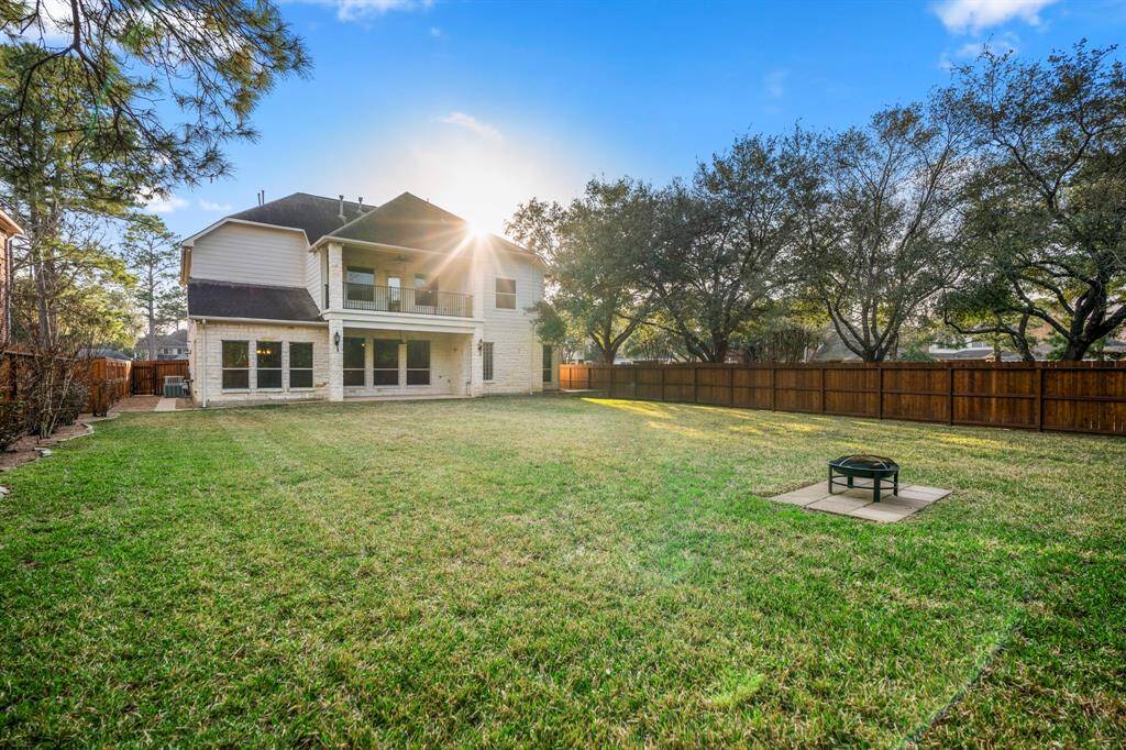 From the back fence, you can admire the beauty of the home’s exterior, with its white limestone masonry and inviting covered patio. The backyard offers plenty of space for outdoor activities, while the design of the home blends seamlessly with the peaceful surroundings.