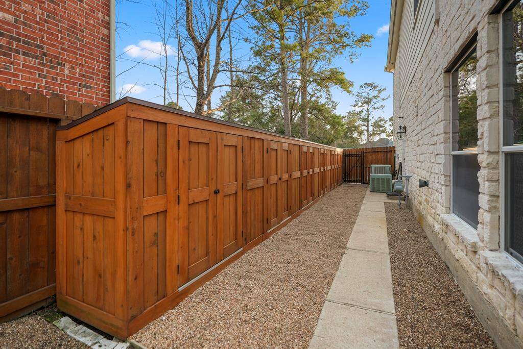 A close-up view of the custom-built storage sheds along the left fenceline showcases their functional design, complete with lighting and electrical hookups. This addition provides ample space for storage and can easily accommodate various tools, equipment, or hobbies.