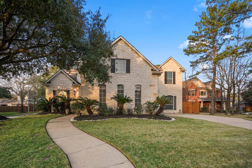 Another view of the front of the home captures the welcoming walkway leading to the front door. To the right, the driveway leads to the swing-entry garage, where a second front door is tucked out of view, providing convenient access and a unique layout.