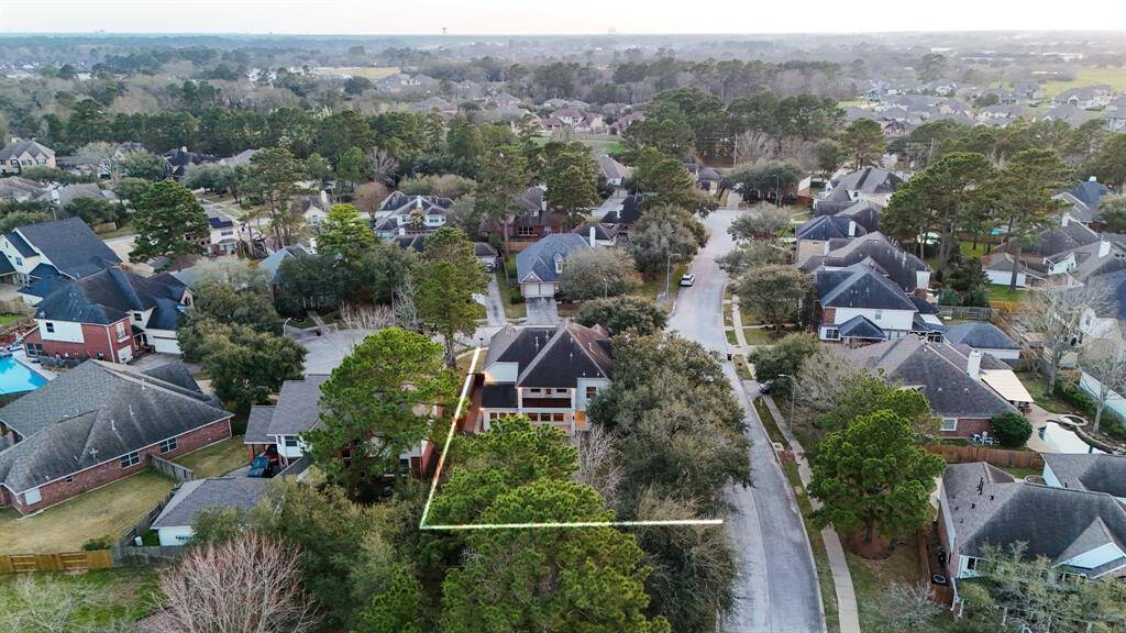 An aerial view highlights the expansive lot size, with the serene park located directly behind the home. In the distance, you can see parts of the Windrose Golf Course, adding to the scenic charm and providing a peaceful backdrop to this beautiful property.