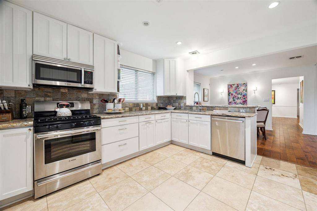 The fleet of stainless steel appliances includes a large LG French door refrigerator and a gas range, dishwasher and microwave by Bosch.