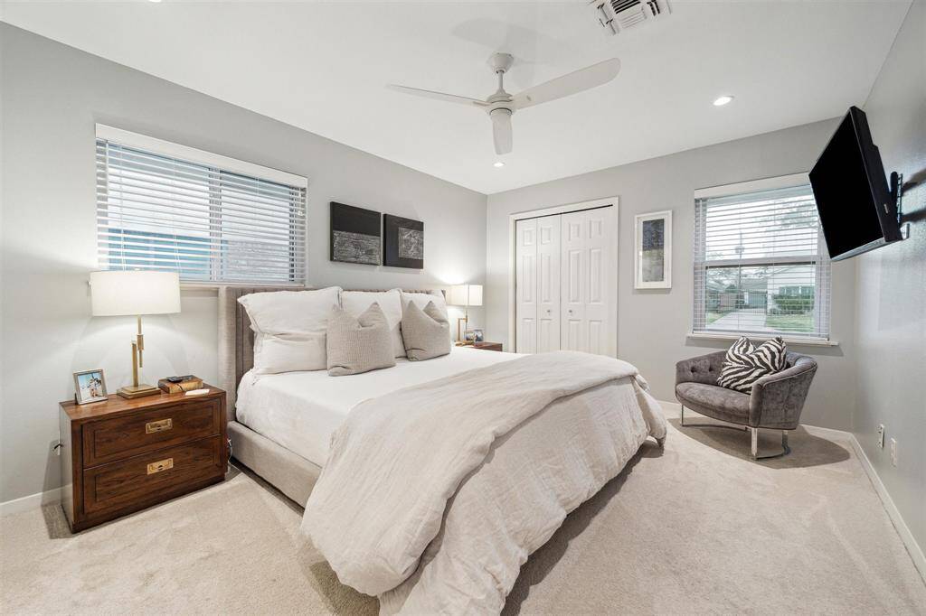 Sleep soundly in the carpeted primary suite featuring double exposures, luxurious carpeting, a ceiling fan, two roomy closets and an en suite bathroom.