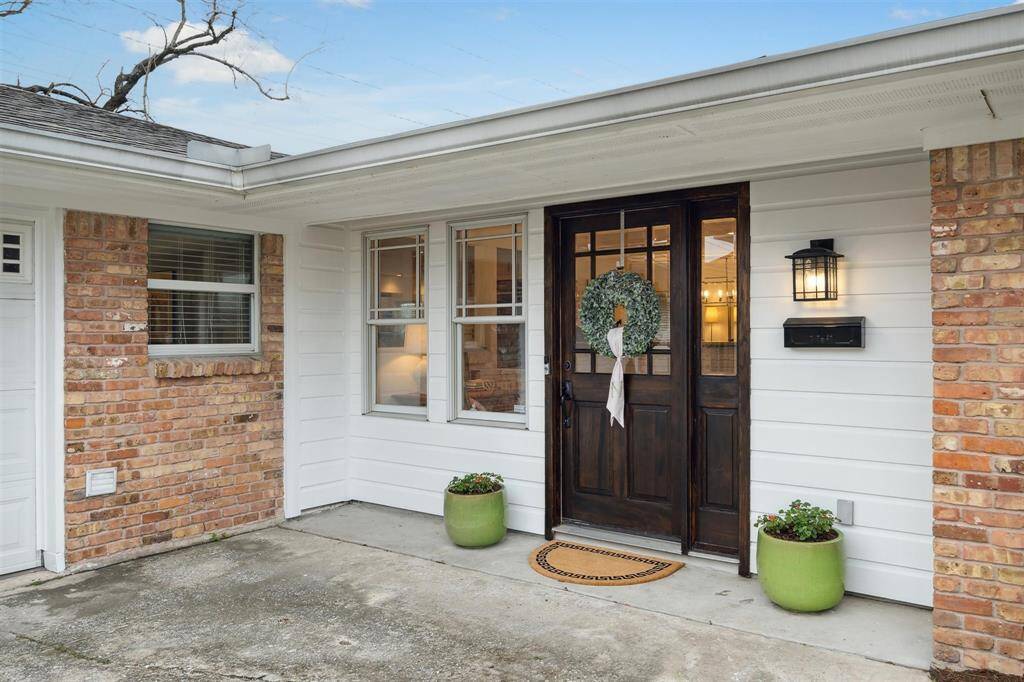 A handsome entry door with inset glass, a tall sidelight and a lantern fixture makes a warm welcome to this 2,049-square-foot home.