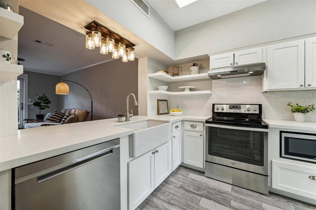 The kitchen is further enhanced with a built-in microwave and a stylish farmhouse sink.
