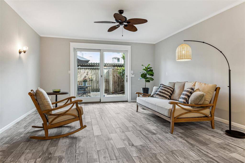 The spacious living room features glass double doors that open to a lovely patio area, flooding the space with an abundance of natural light.
