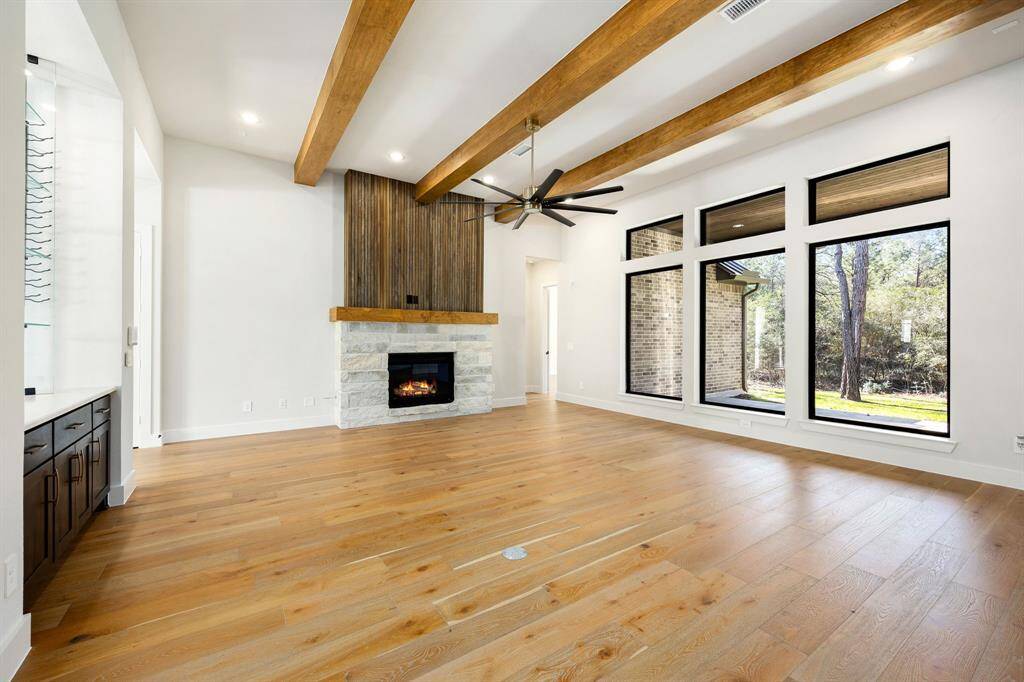 Living Area with high ceilings with wood beams and fireplace