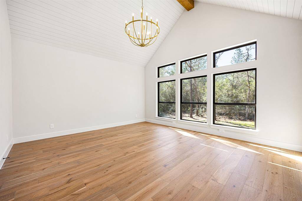 Primary Bedroom with high ceilings, wood beam and shiplap paneling