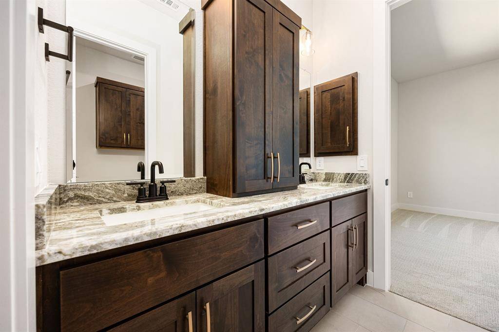 Full bathroom with dual vanities and tons of storage.