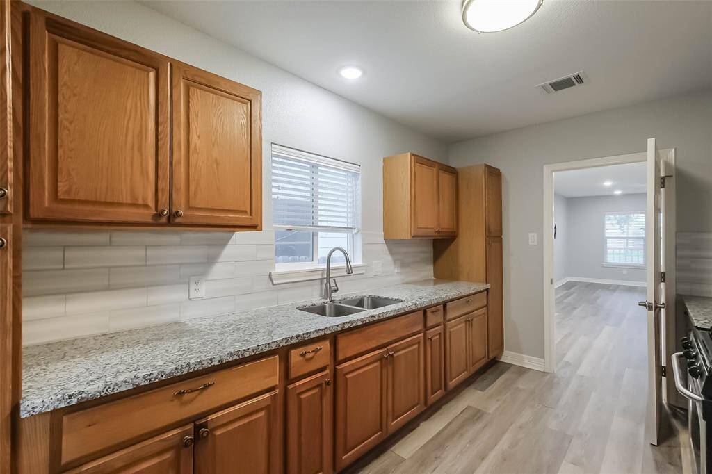The kitchen runs along the back of the home and has been updated to include ample storage and granite counterspace.