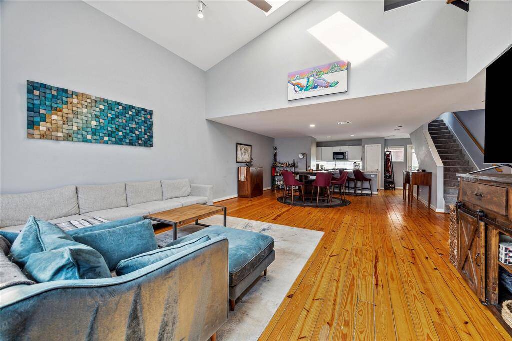View of living, dining, and kitchen. Note how light and bright this is and the high ceiling in the living area.