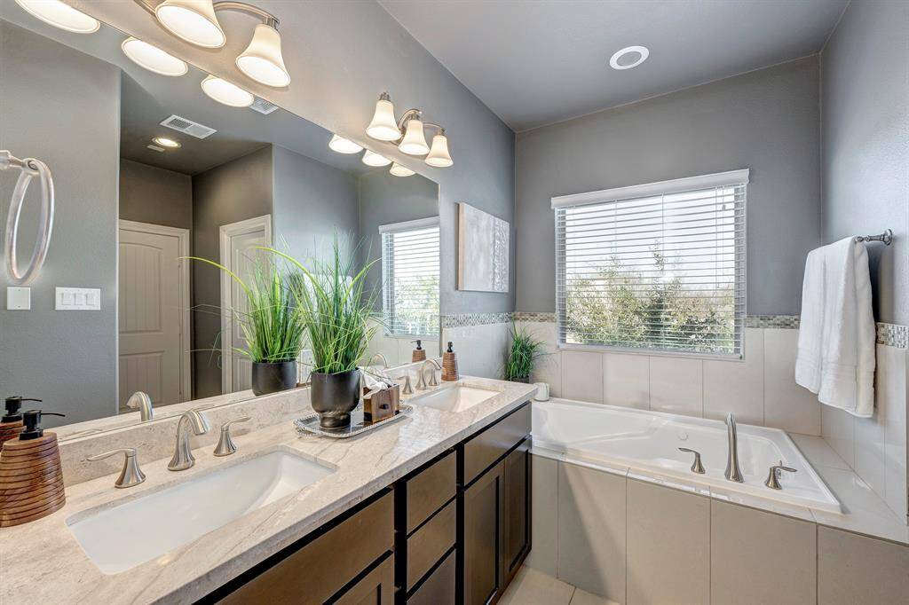 Primary bathroom is well appointed with double sinks and jetted tub.