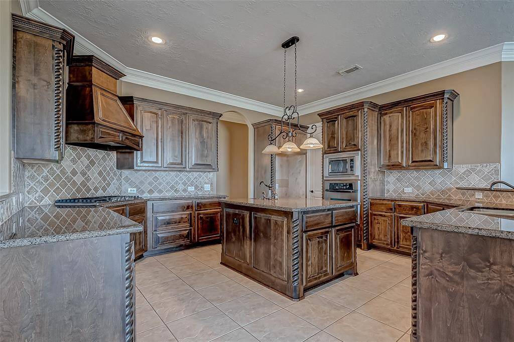 The exquisite kitchen is equipped with gorgeous granite countertops and timeless custom cabinets.  The craftsmanship is displayed in the details.