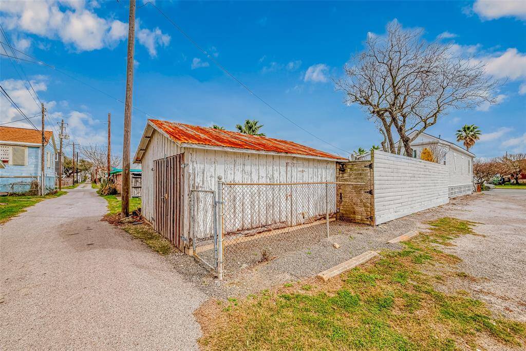 Back of property with alley access, has a nice size storage barn that can also be converted into a garage/parking area if desired. Guests currently park along the side of house or the designated street parking.