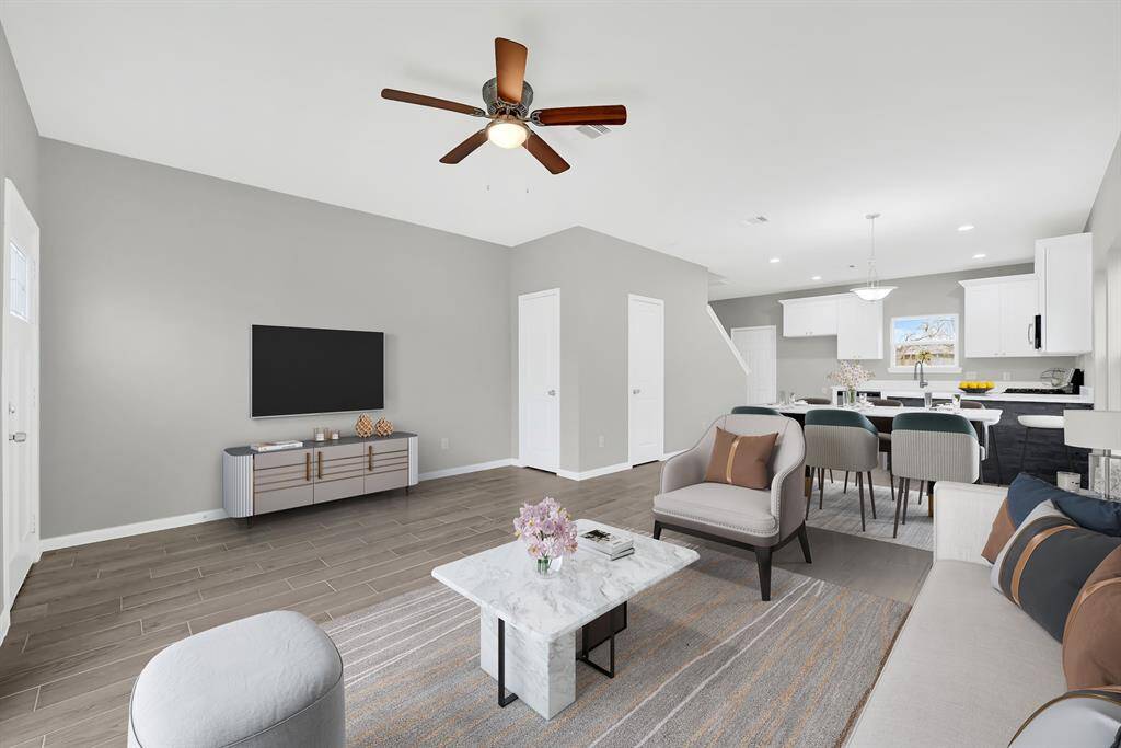 Spacious and elegantly staged living area, seamlessly flowing into a modern kitchen—perfect for relaxation and entertaining.