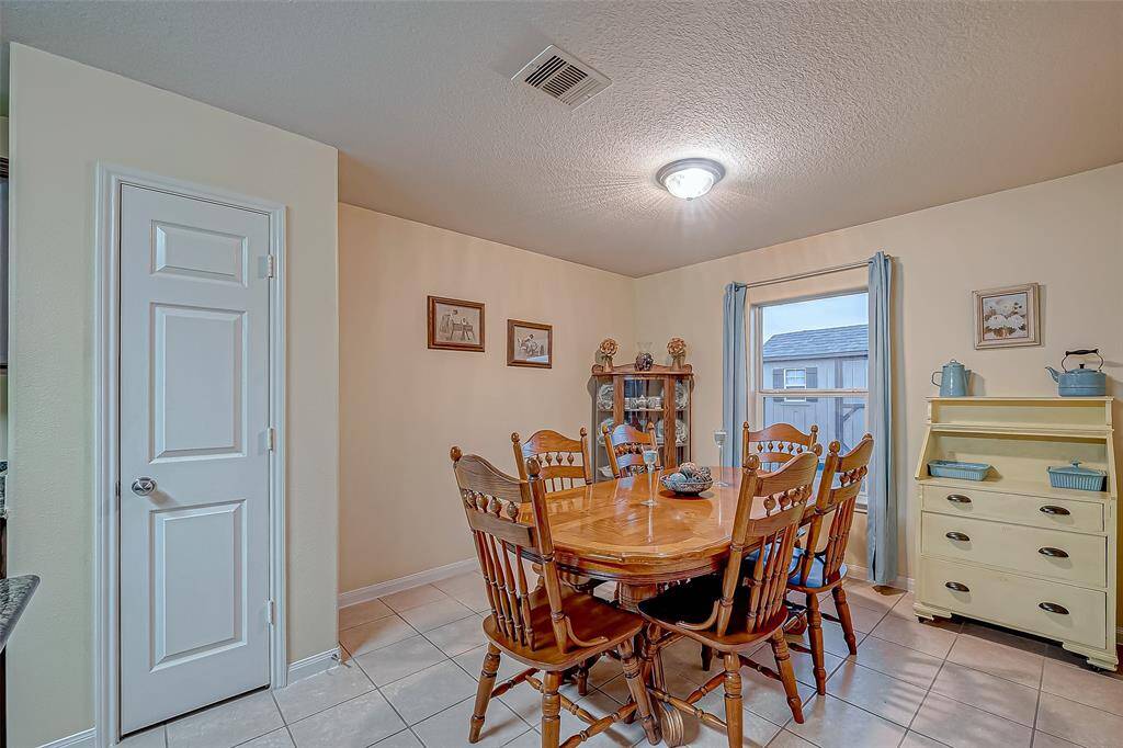 This cozy dining area has tile flooring, and soft neutral walls. The big window offers plenty of natural light.