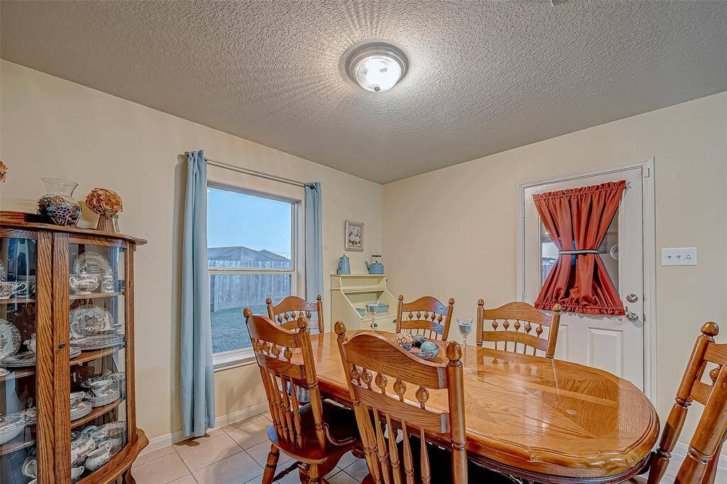 This spacious dining room has space for a big table plus more. There's a door leading outside, offering easy access to the big covered patio in the backyard.  Perfect for entertaining.