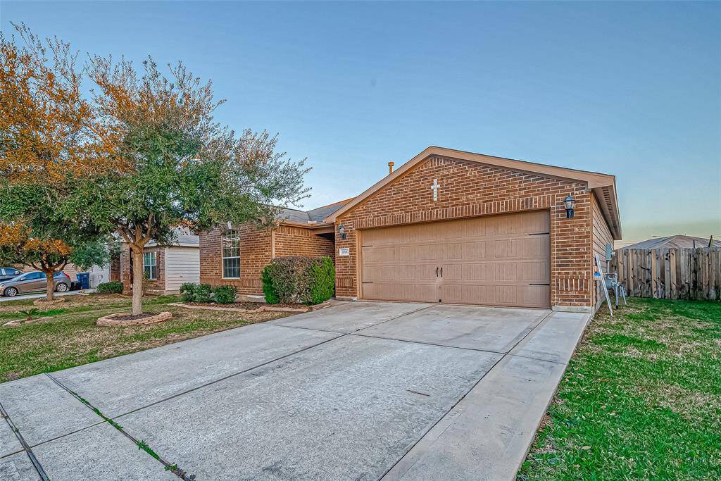 Charming single-story brick home with a spacious two-car garage. The front yard features mature trees and well-maintained landscaping, offering great curb appeal.