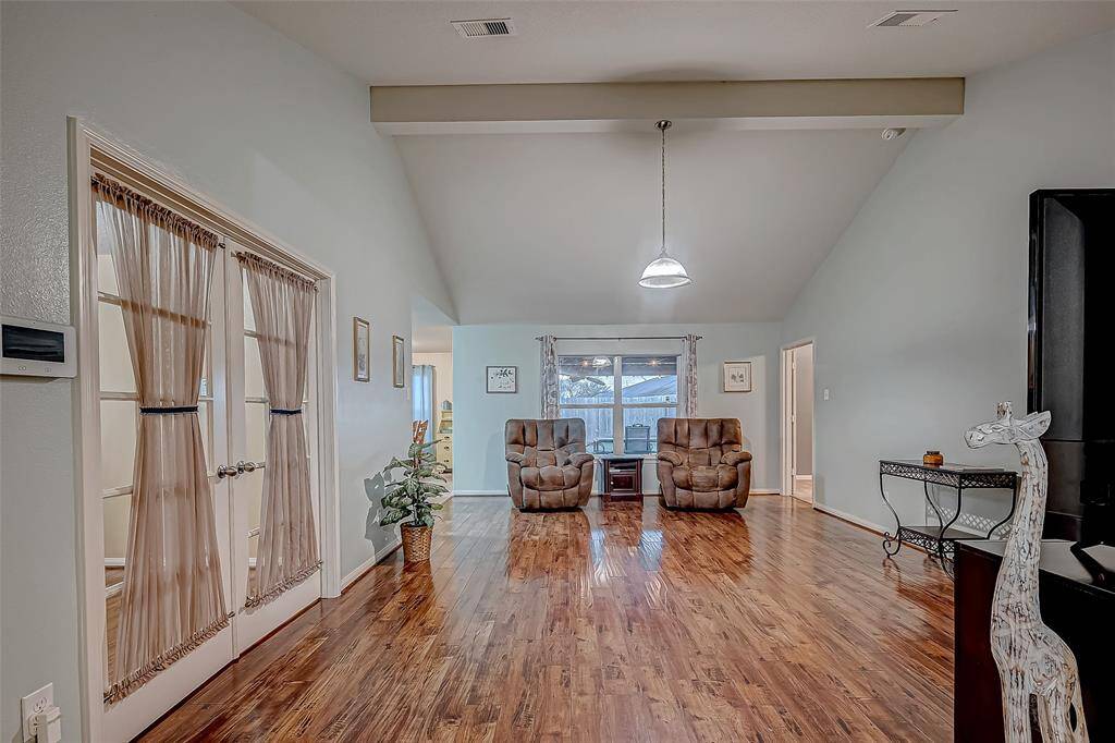 This spacious living area features gorgeous flooring, high ceilings, and ample natural light making this a warm and inviting atmosphere.