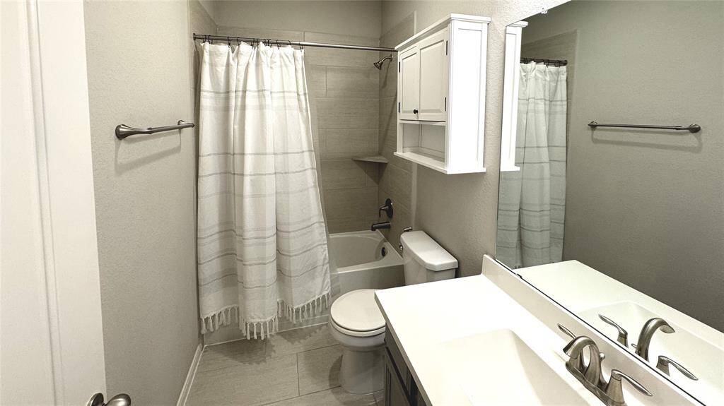 Lots of storage offered in this bright, secondary bathroom.
