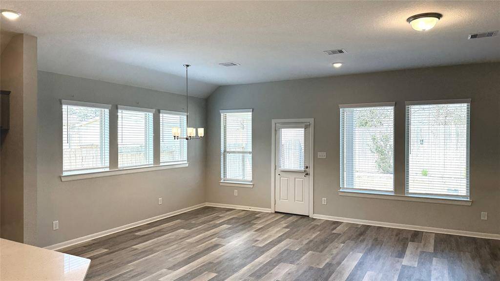 Well-placed windows beautifully illuminate the dining and main living area with natural light while offering a great view of the backyard.