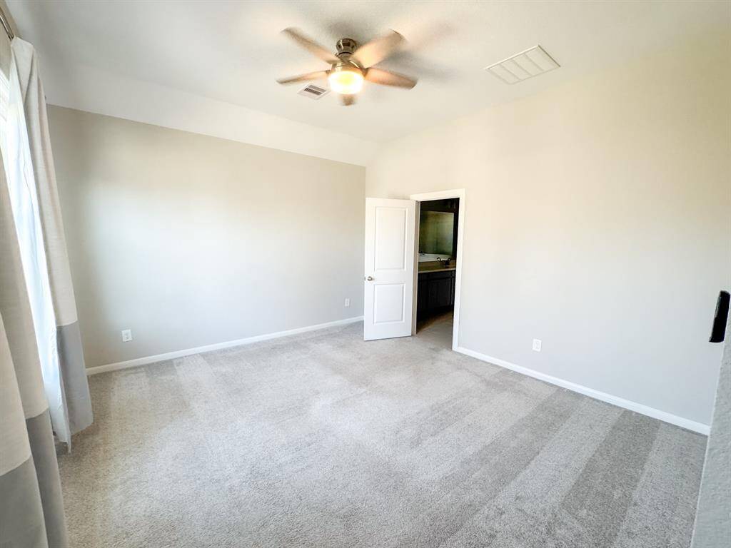 Welcome to your personal retreat! The primary bedroom suite benefits from high ceilings and wash of natural light when the window coverings are drawn.