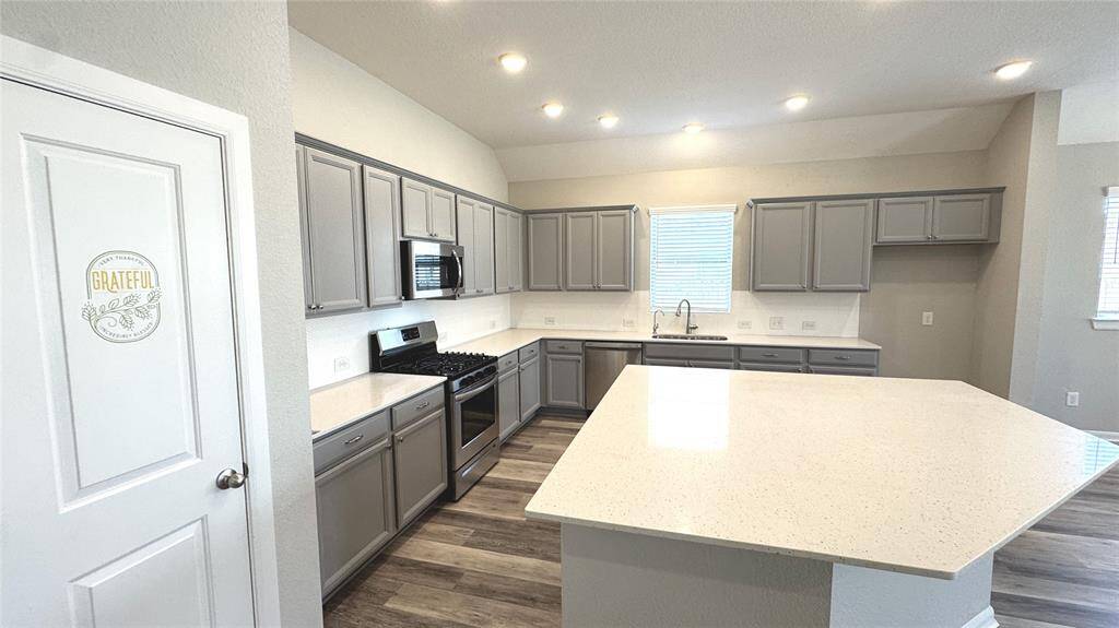 This fabulous kitchen boasts an oversized island where people are sure to gather!