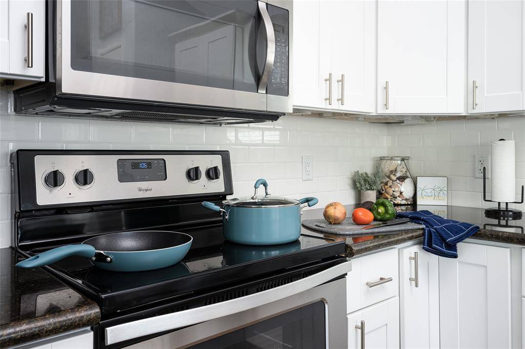 Fully equipped for culinary endeavors, the kitchen boasts a polished finish with a chic subway tile backsplash. The combination of modern appliances and thoughtful design ensures a delightful cooking experience.