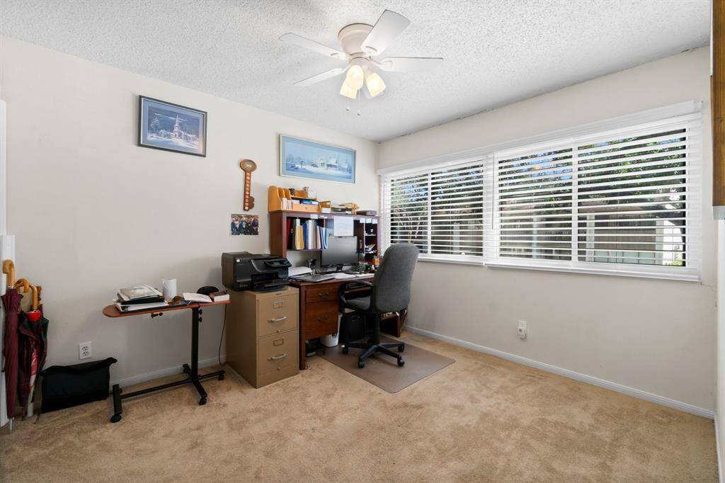 This photo shows the 2nd  with a large window providing ample natural light, with neutral walls and carpet. Ideal for a productive workspace. or secondary bedroom.