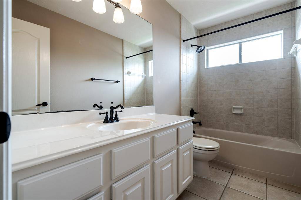 Bright and inviting bathroom featuring a spacious vanity, elegant fixtures, and a relaxing tub. Perfect for unwinding after a long day.
