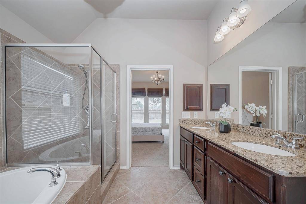 Primary bathroom with separate tub and shower with his and hers sink.