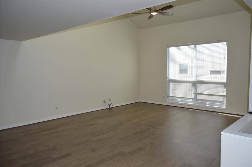 Spacious living area with skylight and large window.