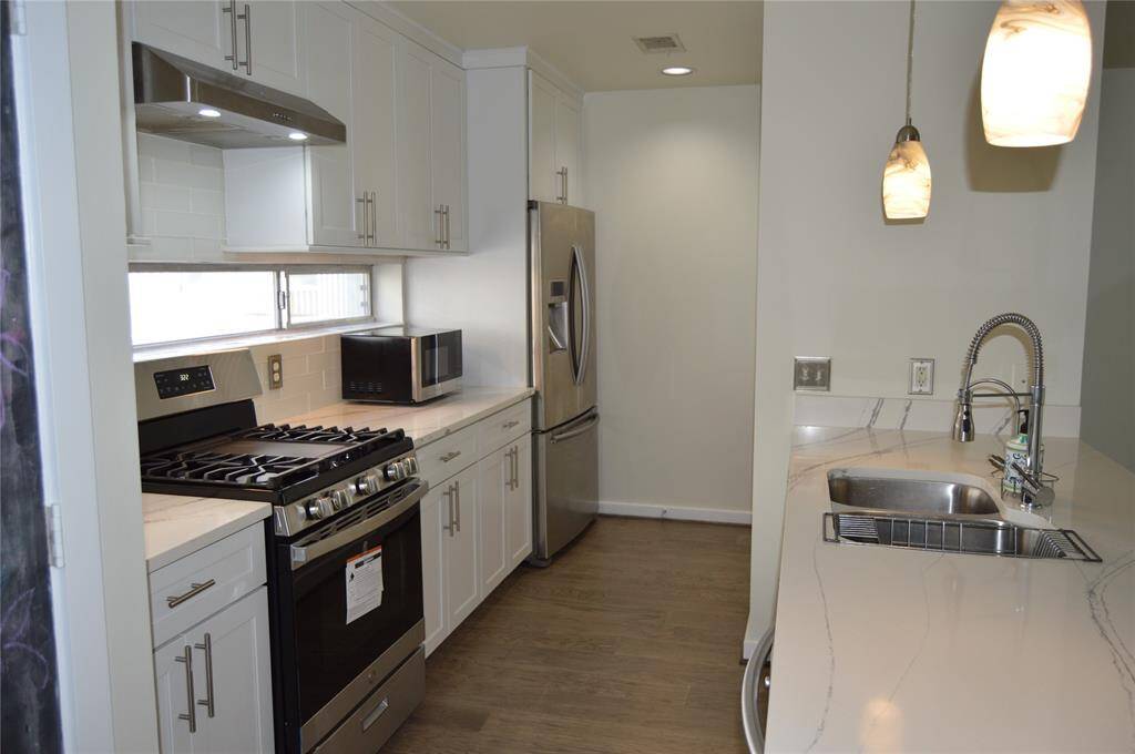 Completely updated kitchen light and bright, excellent storage and pantry space Fun area for barstool arrangement. Great horizontal windows under counters, Recessed lighting. Refrigerator to remain with property.