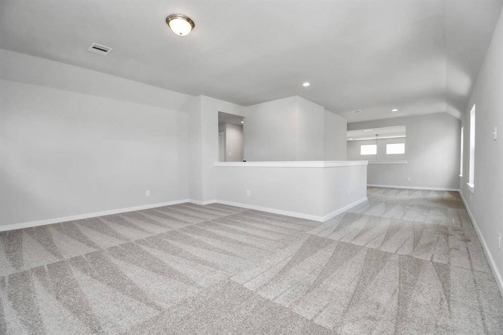 Come upstairs and relish a day of relaxation in this loft area! Ideal as an additional living space or game room, it boasts plush carpeting, high ceilings, custom paint, and windows that flood the area with abundant natural light. Sample photo of completed home. Actual colors and selections may vary.