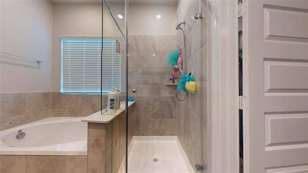 Primary Bathroom offers separate soaking tub and separate glass-enclosed shower.