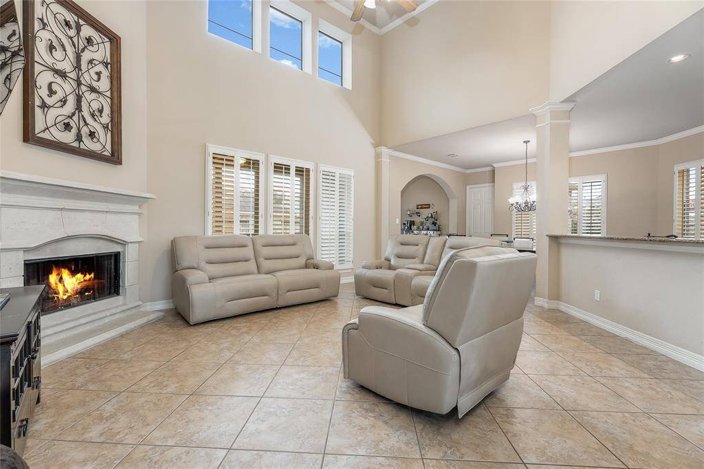 This inviting family room features a cathedral ceiling and a warm fireplace, adding depth and elegance.