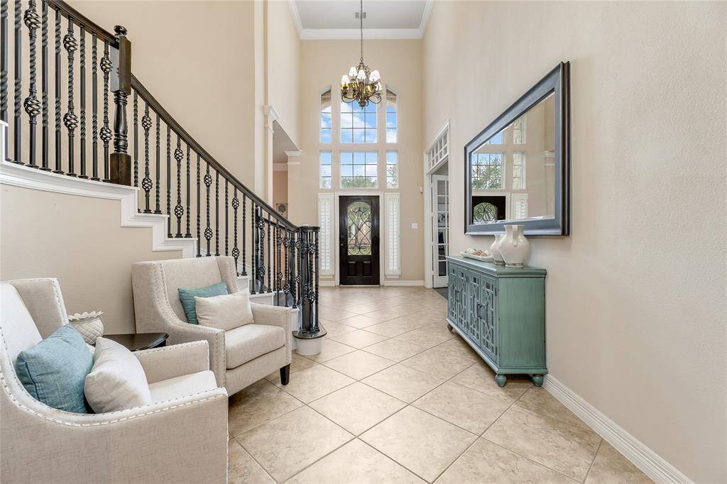 Welcome to an impressive foyer featuring an elegant wrought iron staircase and soaring ceilings that create a stunning first impression.