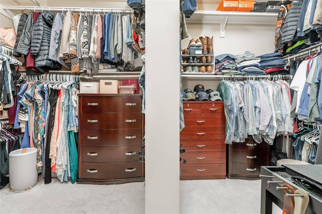Spacious walk-in closet with ample shelving for all your clothing and shoe needs.