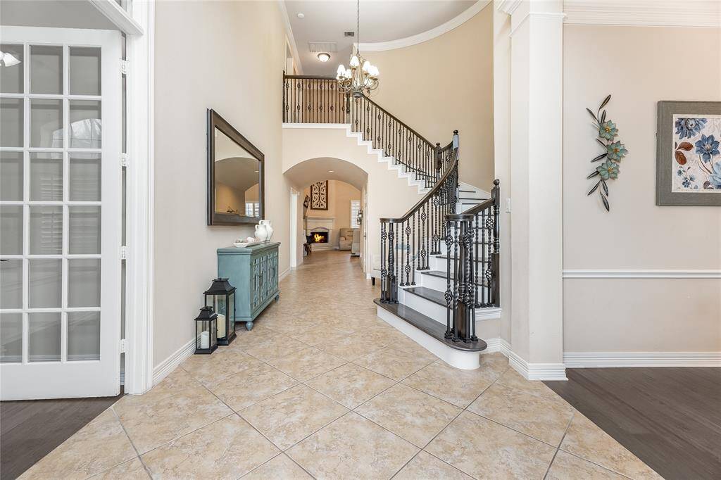 Step into a stunning entryway with soaring ceilings that captivate as you enter this exquisite home.