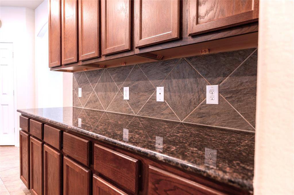 Luxurious granite countertops with abundant storage space.