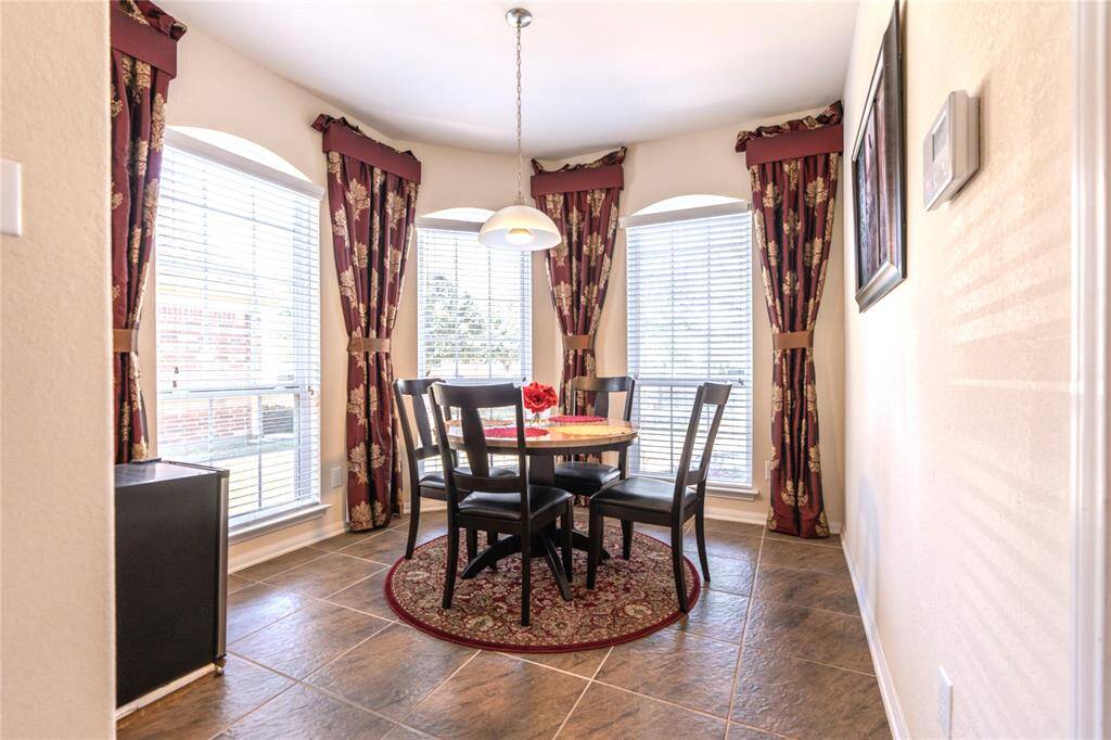 Charming dinette featuring elegant custom window treatments.