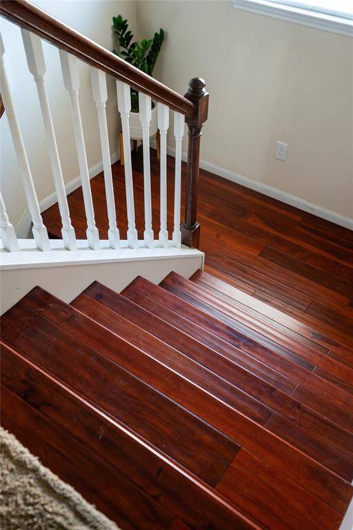 Elegant staircase featuring rich hardwood floors.