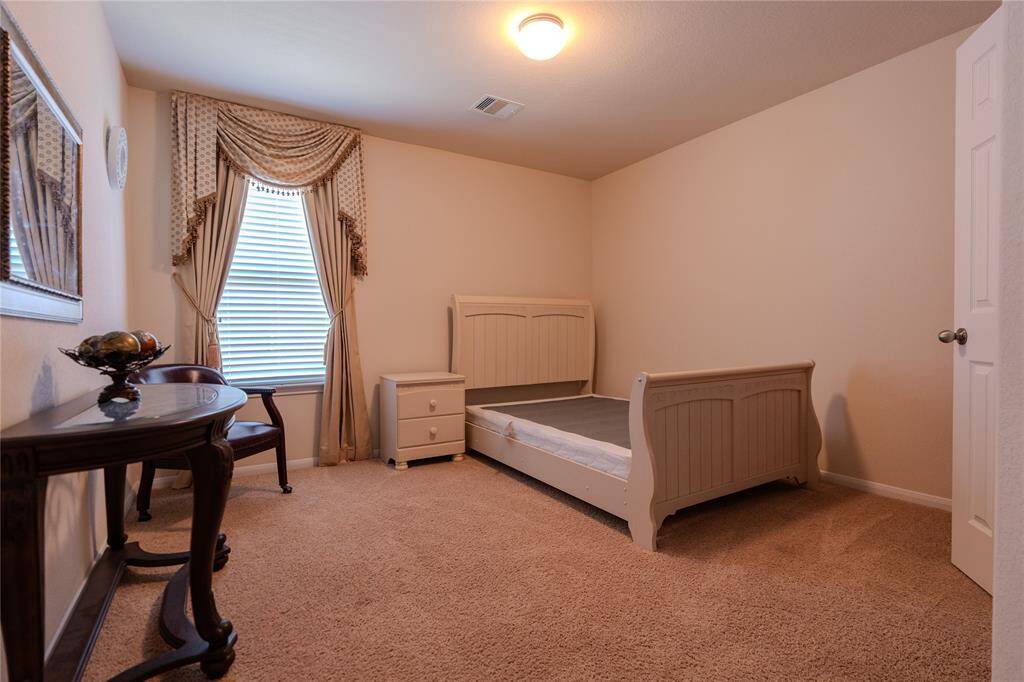 Cozy third bedroom , elegant drapery, and abundant natural light—perfect for relaxation or a stylish guest retreat.