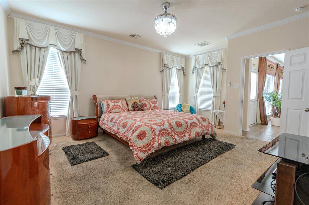 Spacious primary bedroom with a cozy sitting area for relaxation.